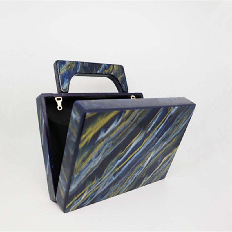 Bolso de noche acrílico con polvo dorado y pintura azul perlado.