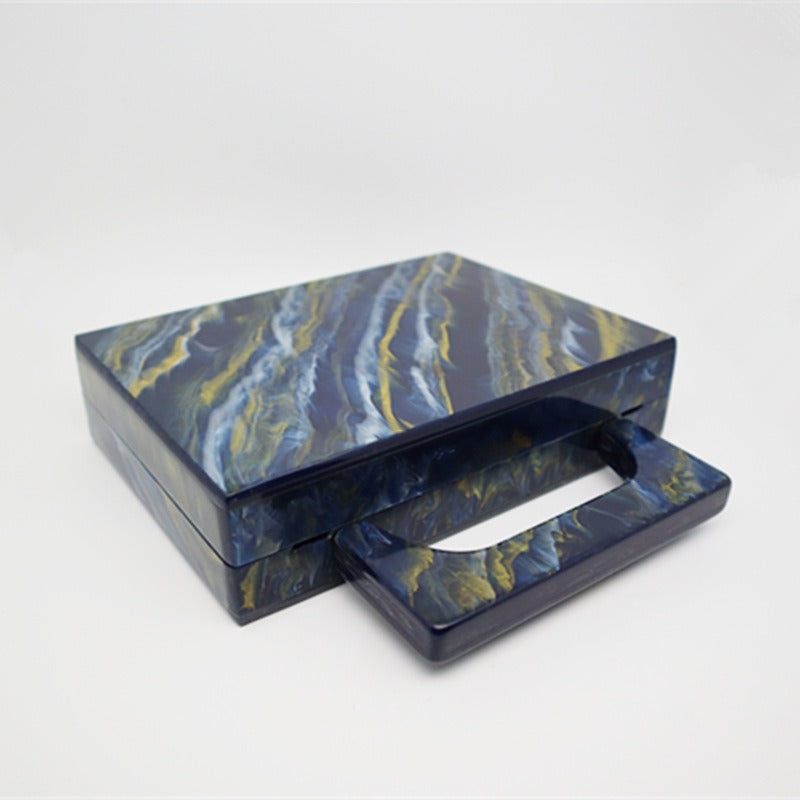 Bolso de noche acrílico con polvo dorado y pintura azul perlado.