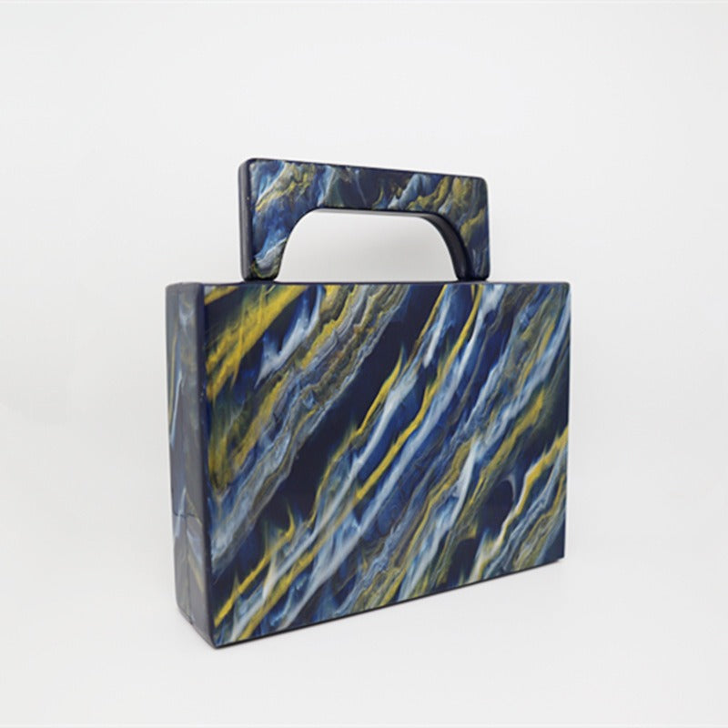 Bolso de noche acrílico con polvo dorado y pintura azul perlado.